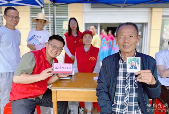 “溫情照相館”攤位上，前來(lái)照相的老人與志愿者開心地合影留念_副本.jpg