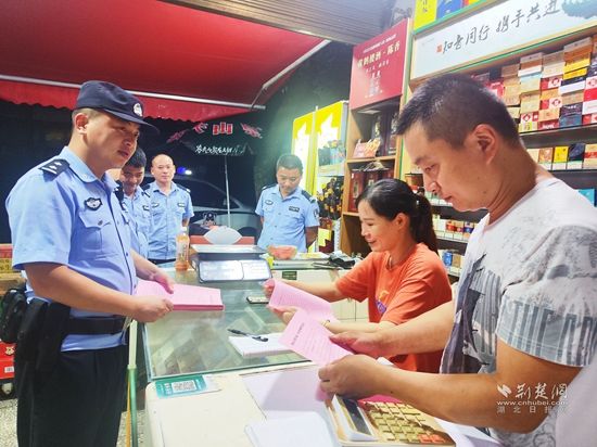 圖為崇陽縣公安局青山派出所民警輔警在轄區(qū)沿街商鋪開展反詐宣傳.jpg.jpg